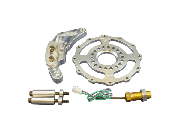 The Innovators West LSX 12-Magnet Crank Trigger Kit for 6.75″ Diameter Damper #7003 includes engine parts: a circular gear, metallic bracket with screws, two cylindrical components, and a sensor with wires on a black background.